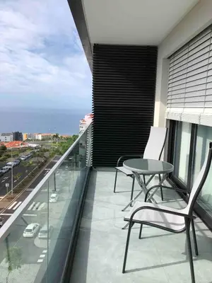 a balcony with a table and chairs on a building at Pilot Ocean View in Funchal