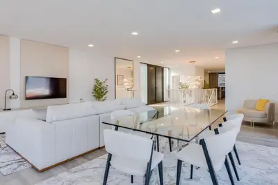 a living room with a glass table and white furniture at Robbie's Place by Holiday Rental Madeira in Santa Cruz