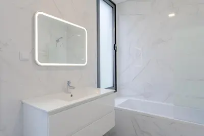 a white bathroom with a sink and a mirror at Robbie's Place by Holiday Rental Madeira in Santa Cruz