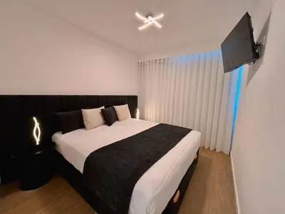 a bedroom with a large bed with a ceiling fan at Star Light Apartment in Câmara de Lobos