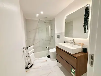 a bathroom with a sink and a toilet and a mirror at Star Light Apartment in Câmara de Lobos
