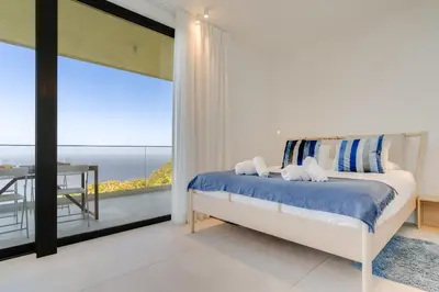 a bedroom with a bed with a view of the ocean at Mar Yam Sea - Ocean View by Atlantic Holiday in Arco de São Jorge