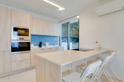 a kitchen with a white counter top and wooden cabinets at Mar Yam Sea - Ocean View by Atlantic Holiday in Arco de São Jorge