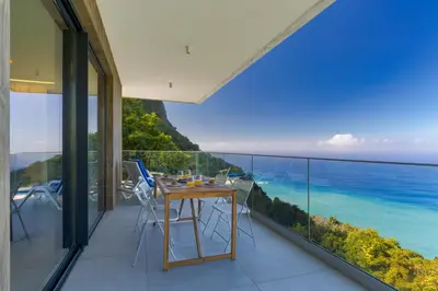 a balcony with a table and chairs and the ocean at Mar Yam Sea - Ocean View by Atlantic Holiday in Arco de São Jorge
