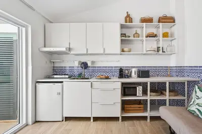 a kitchen with white cabinets and a counter top at Pátio da Luz 1Bdr House by LovelyStay in Luz