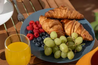a blue plate with croissants and fruit on a table at Pátio da Luz 1Bdr House by LovelyStay in Luz