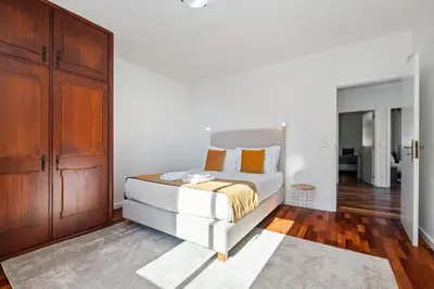 a white bed with orange pillows and towels on it at Johns Villa by Homie in Canhas