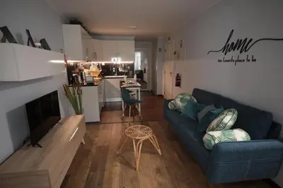 a living room with a blue couch and a kitchen at Apartamentos Baptista by AnaLodges in Funchal