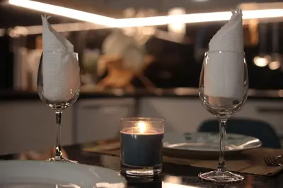 two wine glasses sitting on a table with a candle at Apartamentos Baptista by AnaLodges in Funchal