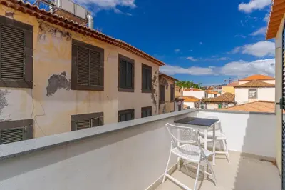 a balcony with two chairs and a table at Apartamentos Baptista by AnaLodges in Funchal