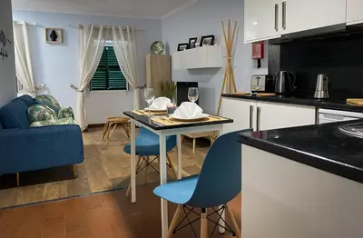a kitchen and living room with a table and chairs at Apartamentos Baptista by AnaLodges in Funchal
