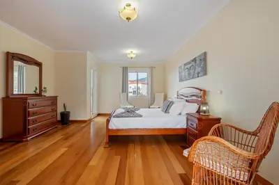 a bedroom with a bed and a dresser and a mirror at Casa Helena in Calheta