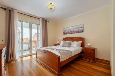 a bedroom with a bed and a large window at Casa Helena in Calheta