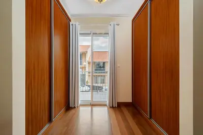an empty hallway with wooden doors and a window at Casa Helena in Calheta