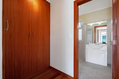 a bathroom with a wooden door and a sink at Casa Helena in Calheta