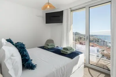 a bedroom with a bed with a view of the ocean at Premium apartment panoramic seaview AtlanticFrame in Câmara de Lobos