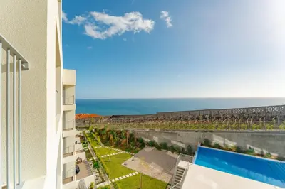 a view of the ocean from the balcony of a building at Atlantic Pearl Pool & Ocean View One Bedroom Apartment in Câmara de Lobos