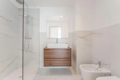 a white bathroom with a sink and a shower at Atlantic Pearl Pool & Ocean View One Bedroom Apartment in Câmara de Lobos