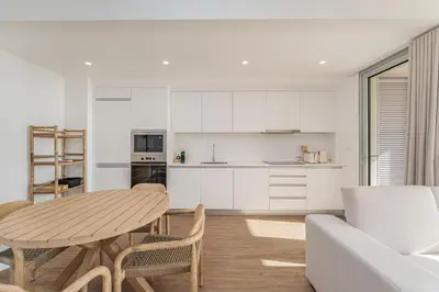 a kitchen and dining room with a table and chairs at Atlantic Pearl Pool & Ocean View One Bedroom Apartment in Câmara de Lobos