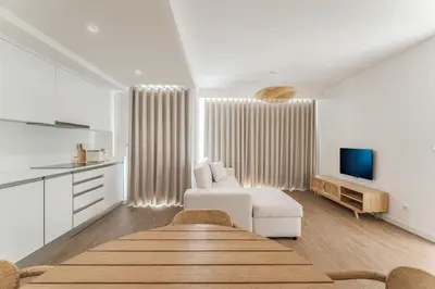 a living room with a white couch and a tv at Atlantic Pearl Pool & Ocean View One Bedroom Apartment in Câmara de Lobos