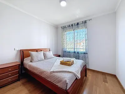 a bedroom with a bed and a window at Sea Garden in Caniço