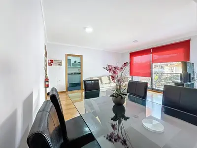 a dining room with a glass table and black chairs at Sea Garden in Caniço