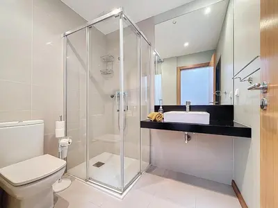 a bathroom with a glass shower and a sink at Sea Garden in Caniço