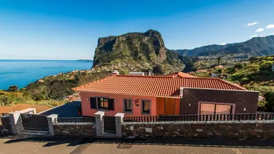 a house on a hill next to the ocean at Vivenda Fortim in Faial