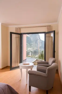 a living room with a couch and a table and a window at Vivenda Fortim in Faial