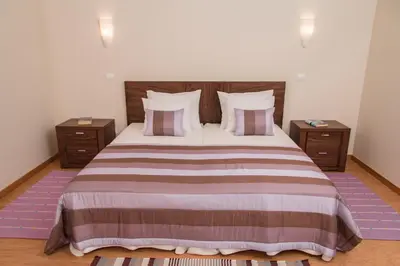 a bedroom with a large bed with two night stands at Vivenda Fortim in Faial