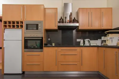 a kitchen with wooden cabinets and a white refrigerator at Vivenda Fortim in Faial