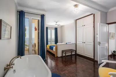 a bedroom with a balcony with a view of the ocean at Villa Beach Club in Santa Cruz