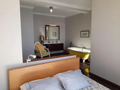 a bedroom with a blue bed and a bathroom at Villa Beach Club in Santa Cruz
