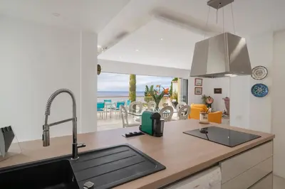 a kitchen with a sink and a view of the ocean at Villa Beach Club in Santa Cruz