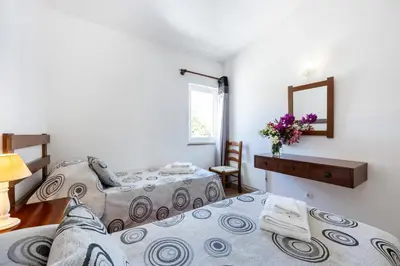two beds in a room with a mirror and a table at Beach Front A in Luz