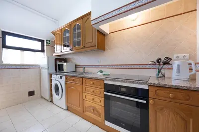 a kitchen with wooden cabinets and a dishwasher at Beach Front A in Luz