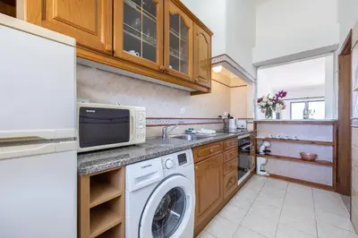 a kitchen with a washing machine and a microwave at Beach Front A in Luz