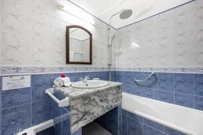 a blue and white bathroom with a sink and a tub at Beach Front A in Luz