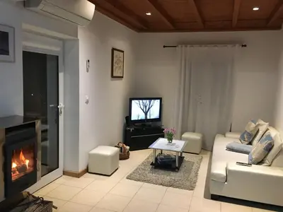 a living room with a fireplace and a couch and a tv at BHF Residences Bordadeira in Arco da Calheta