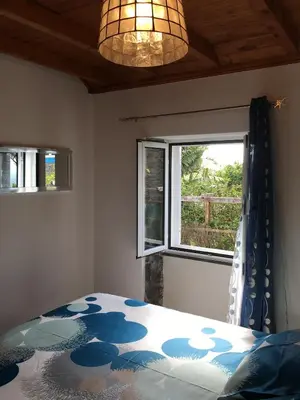 a bedroom with a bed and a window at BHF Residences Bordadeira in Arco da Calheta