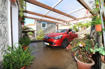 a red car parked in a garage with plants at BHF Residences Bordadeira in Arco da Calheta