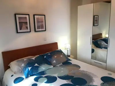 a bedroom with a bed with blue pillows and a mirror at BHF Residences Bordadeira in Arco da Calheta