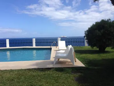 a white chair sitting next to a swimming pool at Salt Water Villa in Santa Cruz