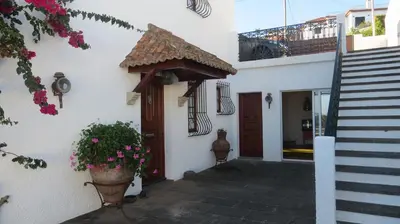 a white building with a door and a potted plant at Salt Water Villa in Santa Cruz