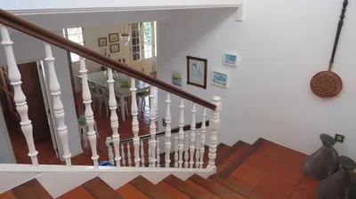 a staircase in a home with white walls and wooden floors at Salt Water Villa in Santa Cruz