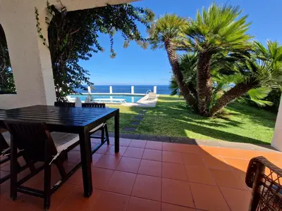 a table and chairs on a patio with a view of the ocean at Salt Water Villa in Santa Cruz