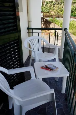 two white chairs and a table on a porch at Casa do Moinho in Santa Cruz