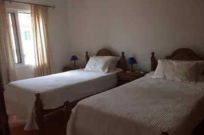 a bedroom with two beds and a window at Casa do Moinho in Santa Cruz