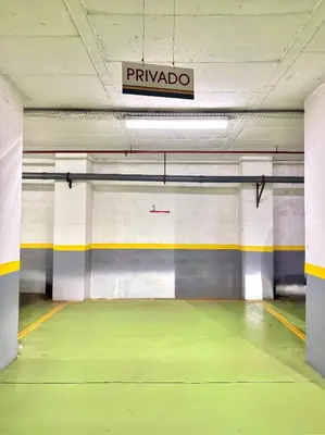 an empty parking garage with a sign on the ceiling at Arriaga Marina Club Apartament in Funchal