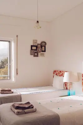a white room with two beds and a window at Apartment Serrão in Funchal